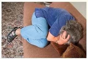 Cower  - Meaning-  To bend low and/or move backwards because you are frightened.