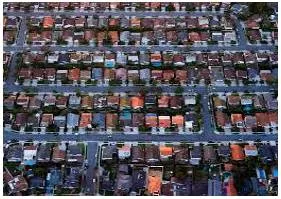 Sprawling  - Spreading out over a large area in an untidy or irregular way.
