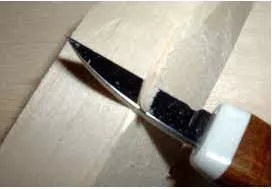 Whittling - To form a piece of wood, etc. into a particular shape by cutting small pieces from it.