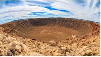 Crater  - A large hole in the ground caused by the explosion of a bomb or by something large hitting it.