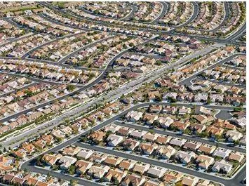 Sprawling - Spreading out over a large area in an untidy or irregular way. (विशाल)