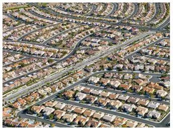 Sprawling - Spreading out over a large area in an untidy or irregular way. (विशाल)