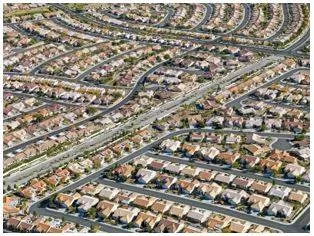 Sprawling - Spreading out over a large area in an untidy or irregular way. (विशाल)
