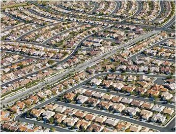 Sprawling - Spreading out over a large area in an untidy or irregular way. (विशाल)