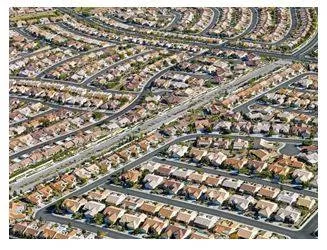 Sprawling - Spreading out over a large area in an untidy or irregular way. (विशाल)