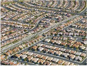 Sprawling - Spreading out over a large area in an untidy or irregular way. (विशाल)