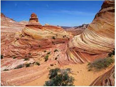 Erosion - Gradually wear away (soil, rock, or land). (घिस)