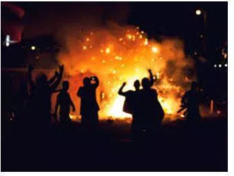Riot - Noisy, violent, and uncontrolled behaviour by a group of people in a public place, often as a protest. (दंगे)