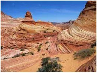 Eroded - Gradually wear away (soil, rock, or land). (घिस)