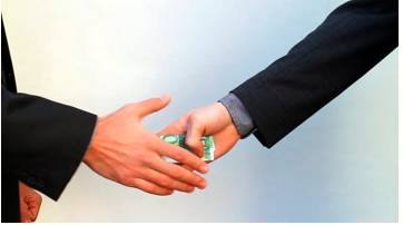 Discreetly  - Meaning: in a careful and prudent manner, especially in order to keep something confidential or to avoid embarrassment.