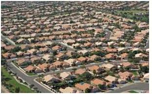 Sprawling  - Spreading out over a large area in an untidy or irregular way.