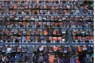 Sprawling  - Spreading out over a large area in an untidy or irregular way.