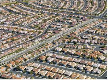 Sprawling - Spreading out over a large area in an untidy or irregular way.