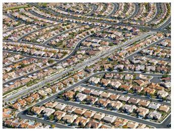 Sprawling - Spreading out over a large area in an untidy or irregular way.