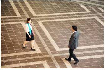 Hovers - To stand somewhere, especially near another person, eagerly or nervously waiting for their attention.