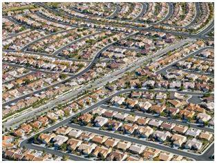 Sprawling - Spreading out over a large area in an untidy or irregular way.