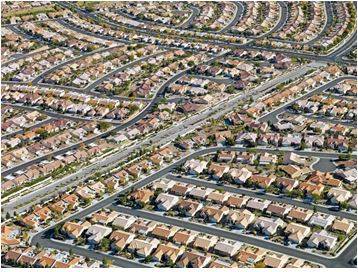 Sprawling - Spreading out over a large area in an untidy or irregular way.