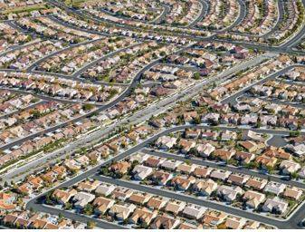 Sprawling - Spreading out over a large area in an untidy or irregular way.