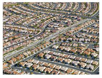 Sprawling - Spreading out over a large area in an untidy or irregular way.