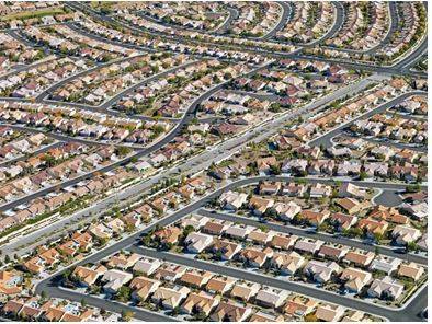 Sprawling - Spreading out over a large area in an untidy or irregular way.